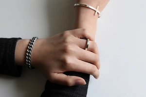 Close-up of minimalist S925 sterling silver square band ring and cuff bracelet on hand