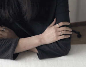 Close-up of S925 sterling silver minimalist rings stacked on hand showing texture