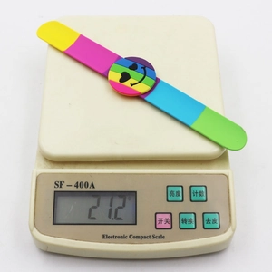 Rainbow silicone snap bracelet with heart smile face emoji on a scale weighing 21.2g
