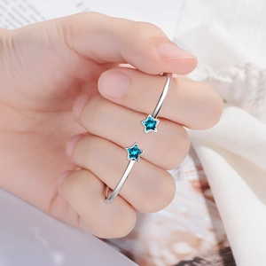 Adjustable silver star bracelet featuring two blue zirconias on a soft fabric background