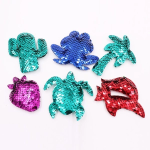 Detail view of assorted sequin patches featuring cactus, shell, and strawberry designs