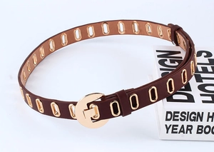 Detail of brown PU leather belt with gold metal eyelets and a round buckle closure