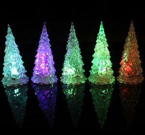 Detail showing five colorful glowing LED Christmas tree night lights on reflective surface