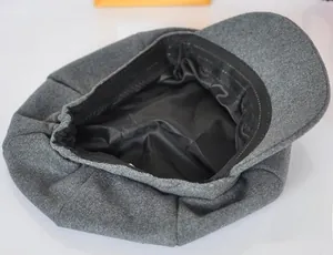 Détail du béret en laine gris foncé montrant la doublure en soie noire et la bande de confort