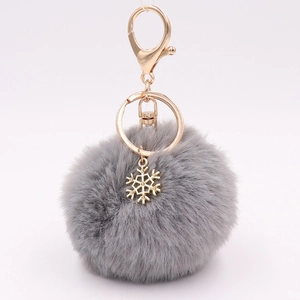 Detail of gray plush keychain with golden alloy snowflake pendant and lobster clasp