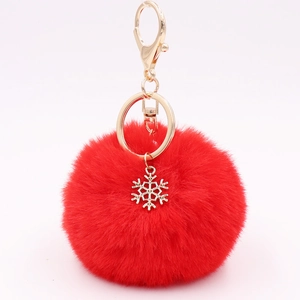 Detailed close-up of a red plush ball keychain with a golden snowflake metal charm