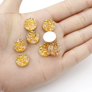 Macro-detail van 12mm ronde hars cabochons met gouden glitters en zilveren platte achterkant