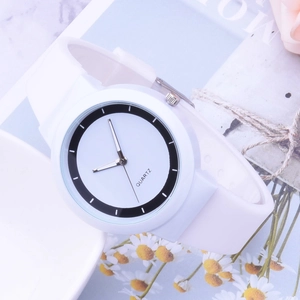 Detail shot of a white minimalist silicone quartz watch on a marble background stand