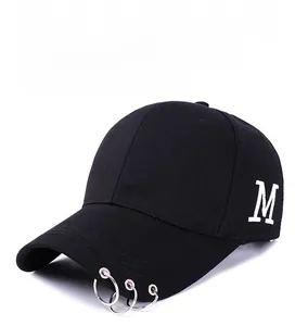 Détail de la casquette noire avec broderie M blanche et anneaux métalliques sur la visière