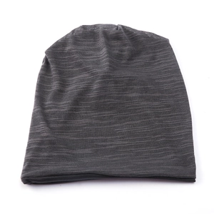 Detail showing the fine texture of dark grey knit fabric on a slouchy winter beanie