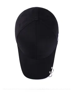 Vue de dessus d'une casquette de baseball noire avec trois anneaux métalliques sur la visière