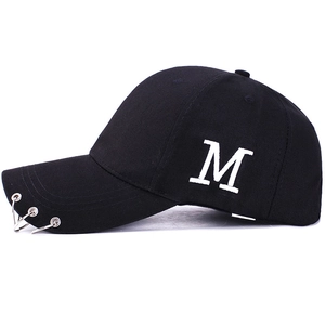 Casquette baseball noire avec broderie M et anneaux métalliques argentés sur la visière