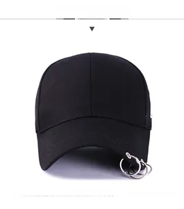 Détail de la casquette en coton noir avec trois anneaux métalliques argentés sur la visière