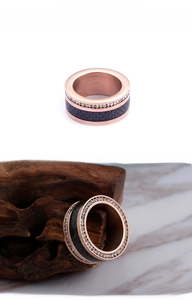 Close-up of rose gold stainless steel ring with black texture and pave crystals