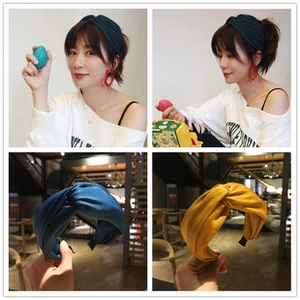 Detailed views of wide knotted fabric headbands in dark cyan and ginger yellow colors