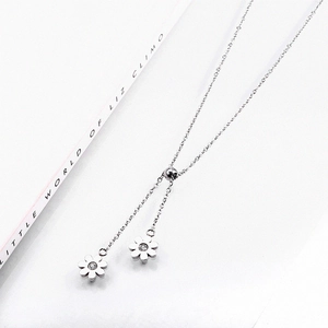 Detail of silver sun flower pendant necklace with diamonds on minimalist white background