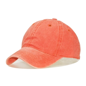 Detail of coral red washed cotton baseball cap with vintage texture and stitching