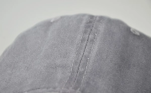 Close-up of grey washed cotton baseball cap showing twill fabric texture and stitching