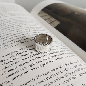 925 sterling silver open ring with vintage beaded edges on an artistic book background