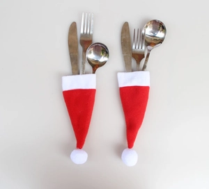 Close-up of mini Santa hat cutlery holders with red and white plush for table decor