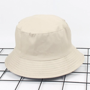 Gros plan du chapeau bob en sergé de coton beige sur une surface métallique noire