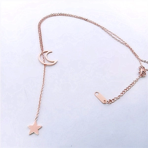 Detail of rose gold double layer necklace with crescent moon and star pendants