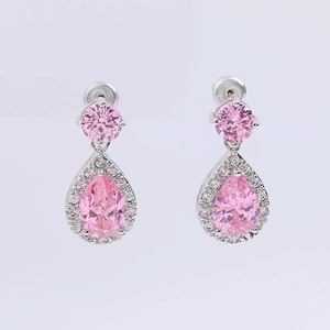 Detail of pink pear-cut zircon earrings with silver plating and surrounding crystals