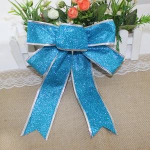 Close-up of a 25cm blue glitter Christmas bow with silver trim for tree decoration