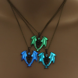 Luminous winged skull necklaces glowing in vibrant green, blue and cyan colors