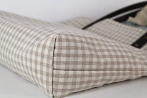 Detail shot of sturdy stitching and natural plaid fabric texture on a Japanese tote bag