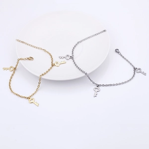 Bracelets de cheville en acier titane or et argent avec pendentifs clés sur blanc