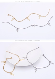 Détail des bracelets de cheville avec pendentifs clés en or et argent sur plateau