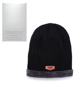 Detail of black knit beanie with soft grey fleece lining and premium brown leather patch