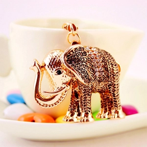 Exquisite gold elephant keychain with sparkling rhinestones on a decorative background