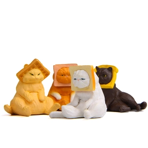 Close-up of four cute plastic cat figurines wearing toast and waffle headwear decor
