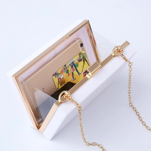 White square acrylic evening bag with gold metal frame and cherry detail on white backdrop