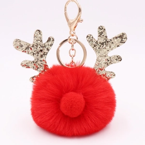 Detail of red plush Christmas reindeer keychain with golden sequin antlers and metal clasp