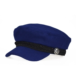 Detailed view of dark blue wool newsboy cap with braided strap and silver crown button