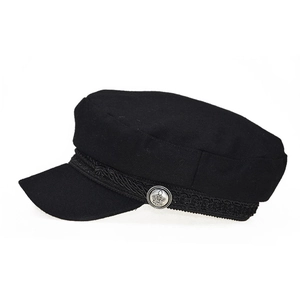 Close-up of black wool newsboy hat featuring a braided trim and silver crown button