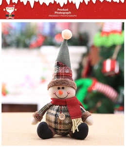 Detail of Christmas snowman plush doll featuring plaid hat and red tassel scarf