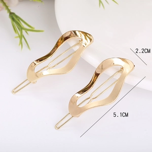 Set of two gold wave alloy hair clips with mirror finish on minimalist background
