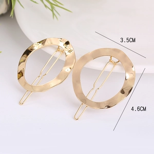Detail view of two gold geometric hair clips with sizes 3.5cm and 4.6cm on white tray