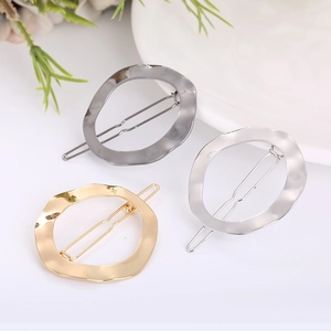 Detailed view of irregular round hair clips in gold, silver, and gunmetal finishes