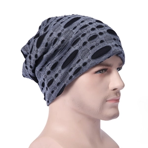 Detail of grey and black distressed knit beanie featuring hollowed-out dot textures