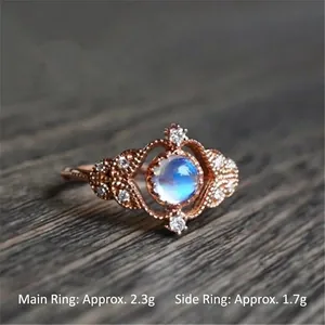 Vintage Mondstein und Zirkon Ring-Set mit Roségold-Finish auf dunklem Holzgrund