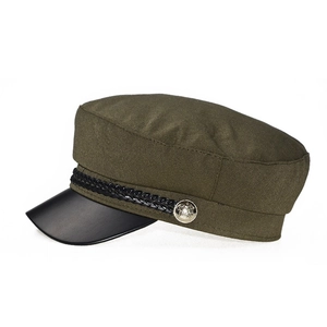 Detail of army green navy hat featuring black leather brim and silver metal buttons