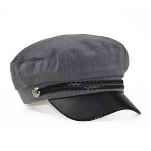 Close-up of baker boy hat with grey fabric body, leather brim and silver metal button