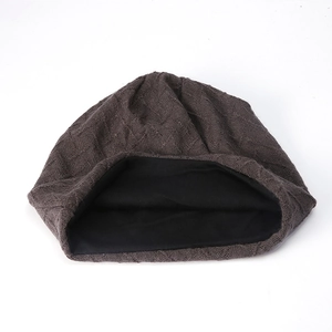 Dettaglio del berretto in maglia marrone scuro con morbida fodera in pile termico nero