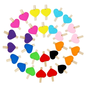 Colorful heart wooden clips for photos arranged in a creative spiral pattern on white