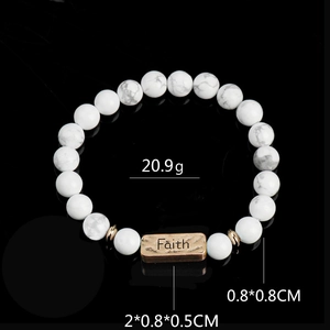 Detailed macro view of white marble stone beads bracelet with bronze Faith engraved plaque